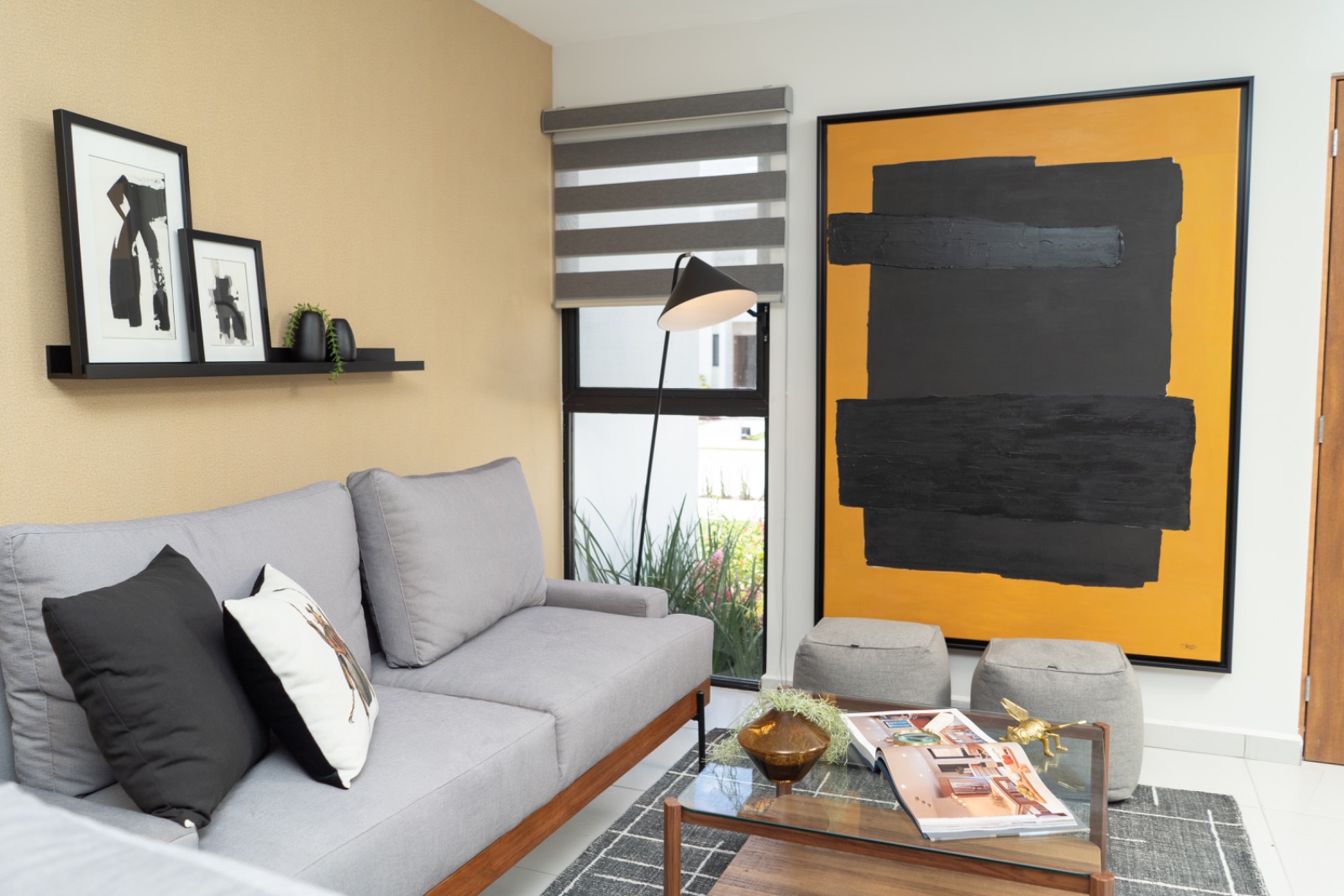 Sala de casa muestra con sofá gris y arte contemporáneo