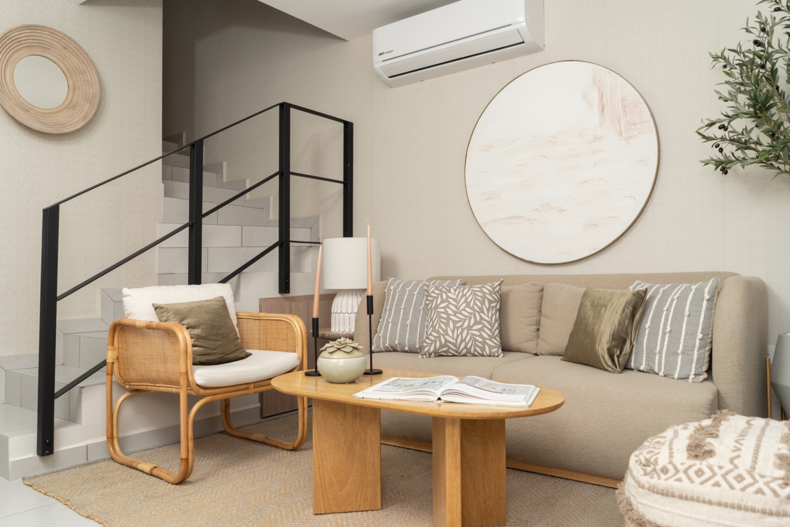 Sala con escalera y sillón de ratán en casa muestra
