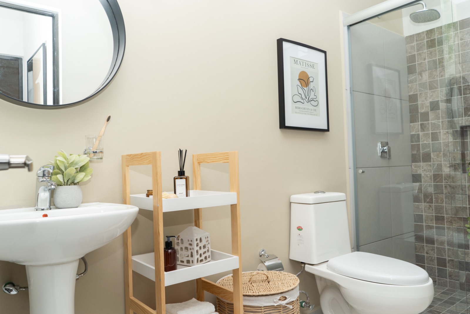 Baño de casa muestra con espejo redondo y regadera