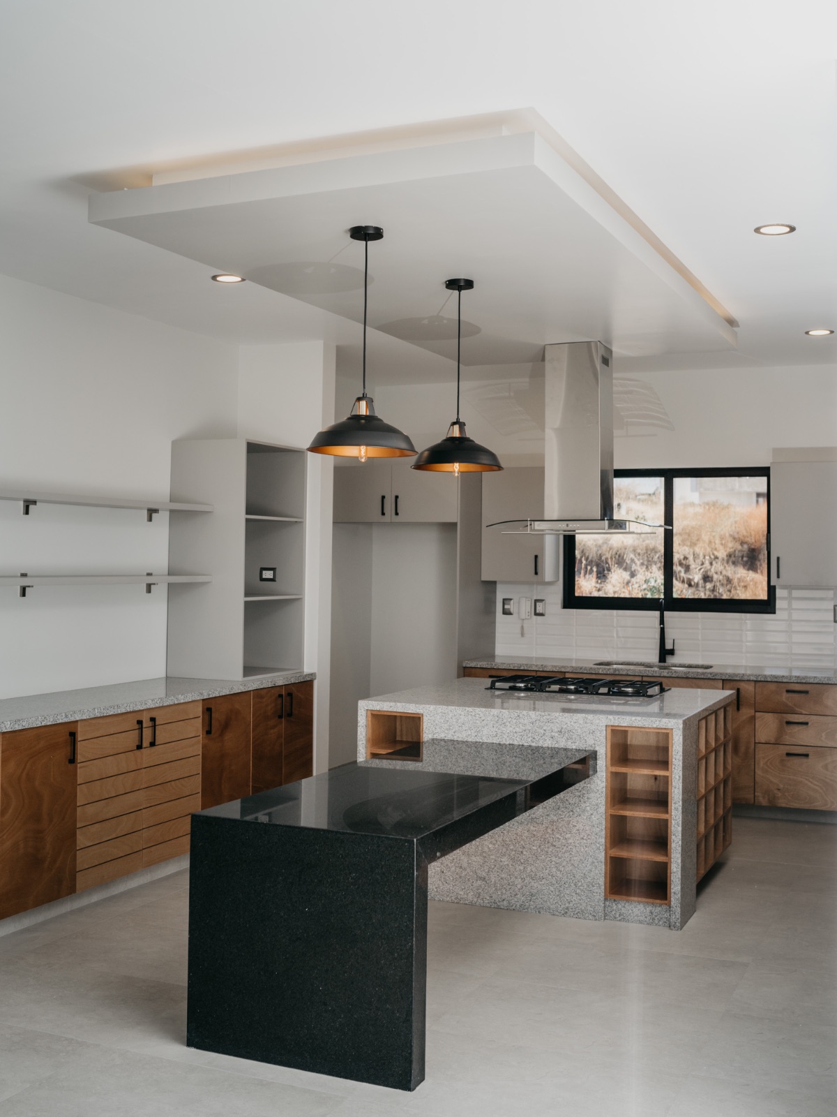 Cocina moderna con isla oscura y lámparas